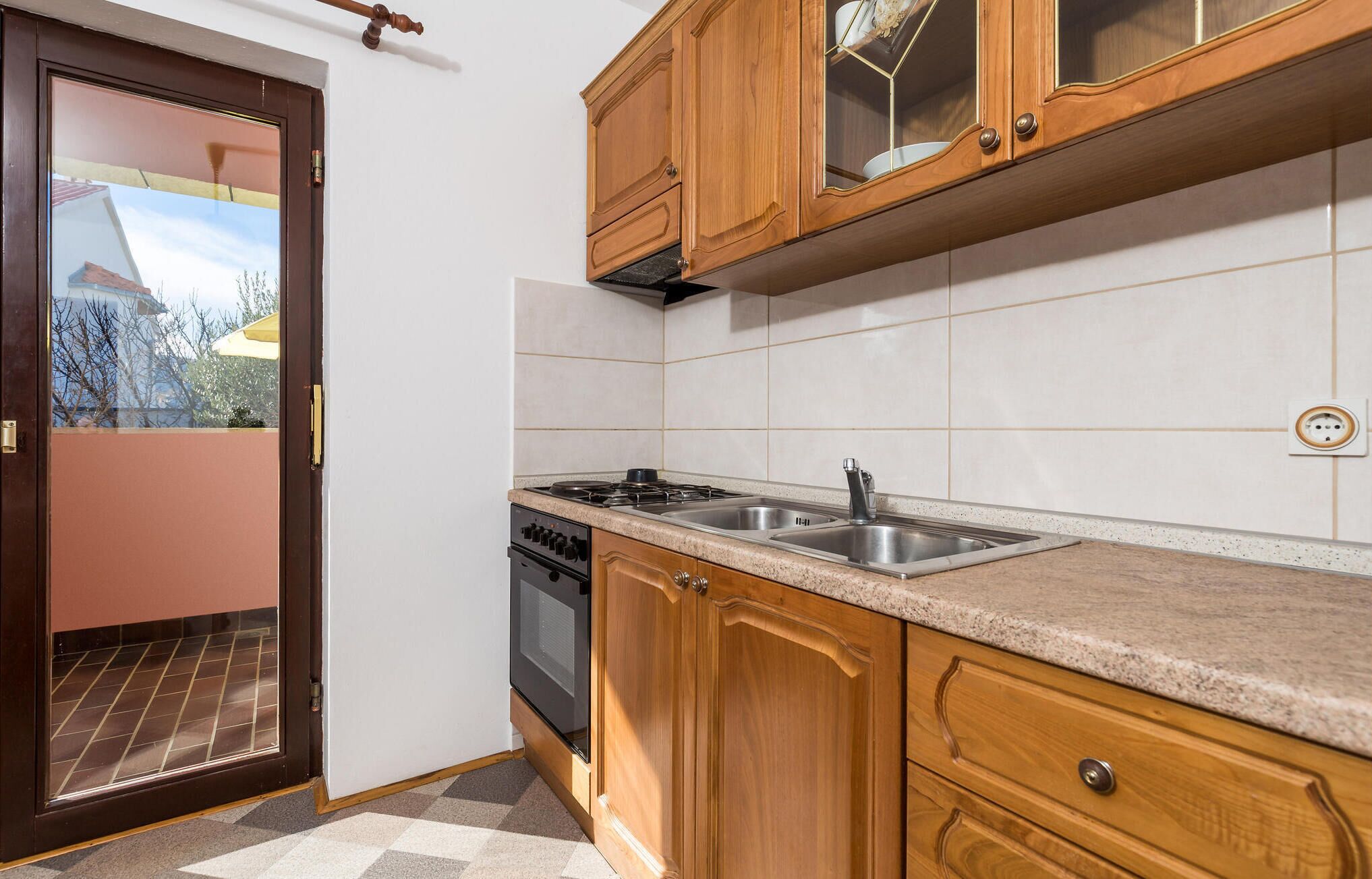 Una cocina con armarios de madera, una estufa y un fregadero.
