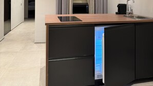 A modern kitchen with a built-in dishwasher, a sink, and a coffee maker. - LEOPOLDO SUITES (Cagliari)