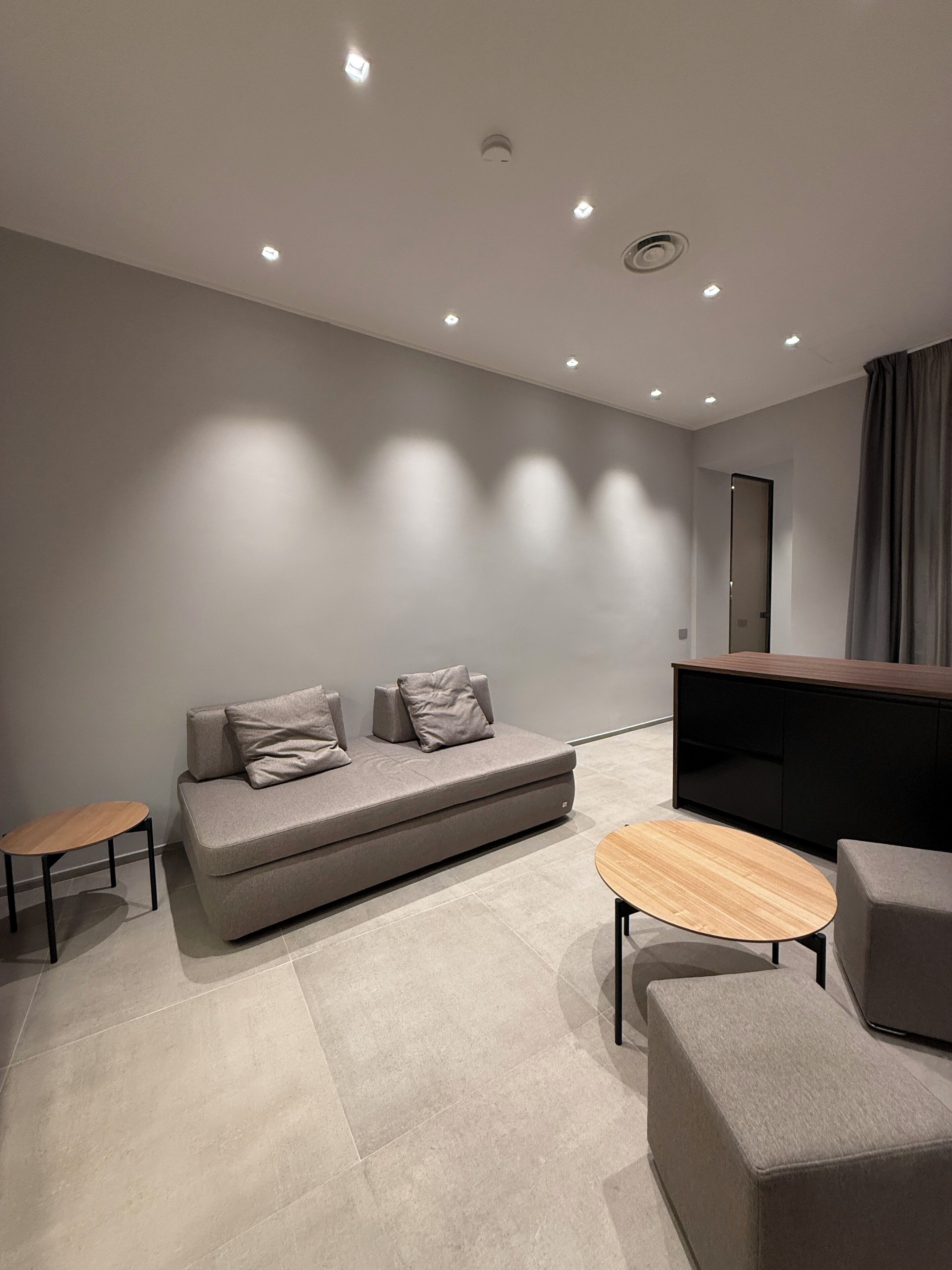 A modern living room with a sofa, a coffee table, and a TV stand.