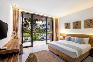 A modern hotel room with a large bed, a flat-screen TV, and a sliding glass door leading to a balcony with outdoor furniture. - Villa Florentine by BaliSuperHost (Bali)