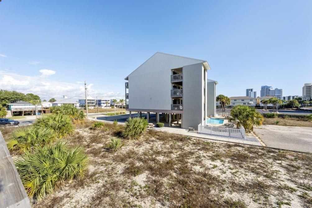 A modern building with a flat roof, a balcony, and a swimming pool.