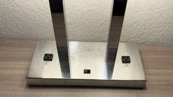 Toma de corriente metálica rectangular con dos enchufes, un interruptor y una etiqueta que indica un máximo de 3.5A, 120V y 60Hz.