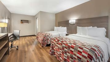 Een hotelkamer met twee bedden, een bureau en een stoel.