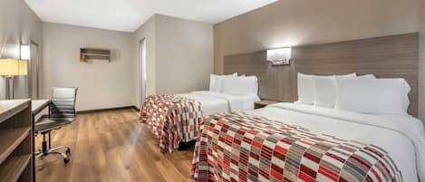 A hotel room with two beds, a desk, and a chair.