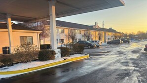 A residential street with houses, parked cars, and a snow-covered sidewalk. - Red Roof Inn Kokomo (Kokomo)