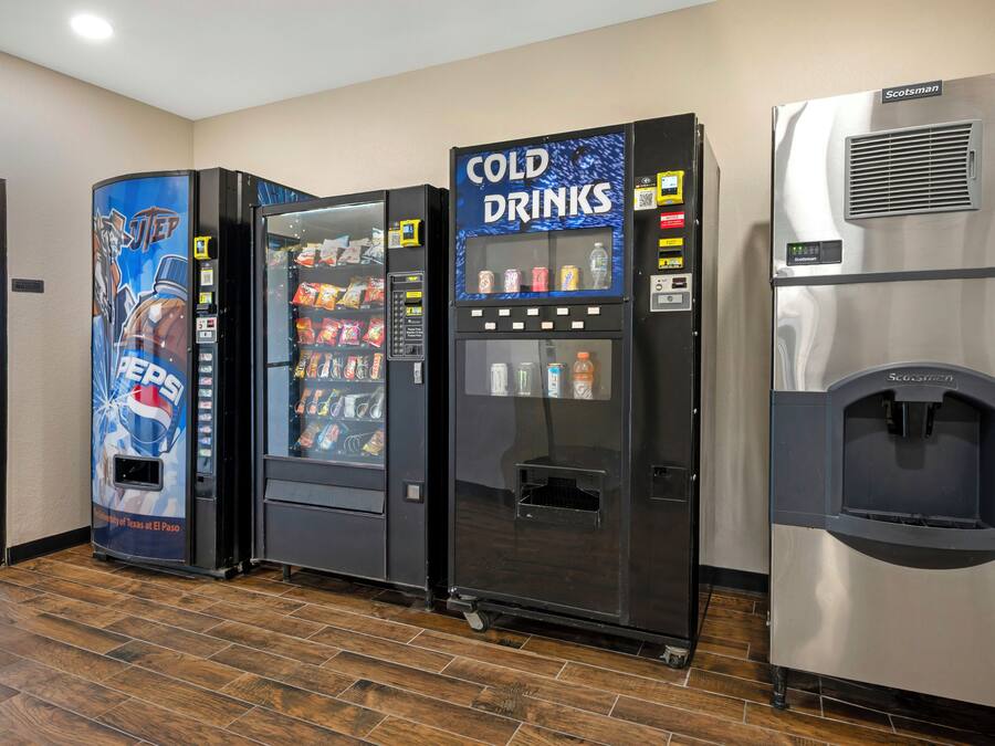 Tre distributori automatici, uno per Pepsi, uno per bevande fredde e uno per acqua, in una stanza con pavimento in legno.