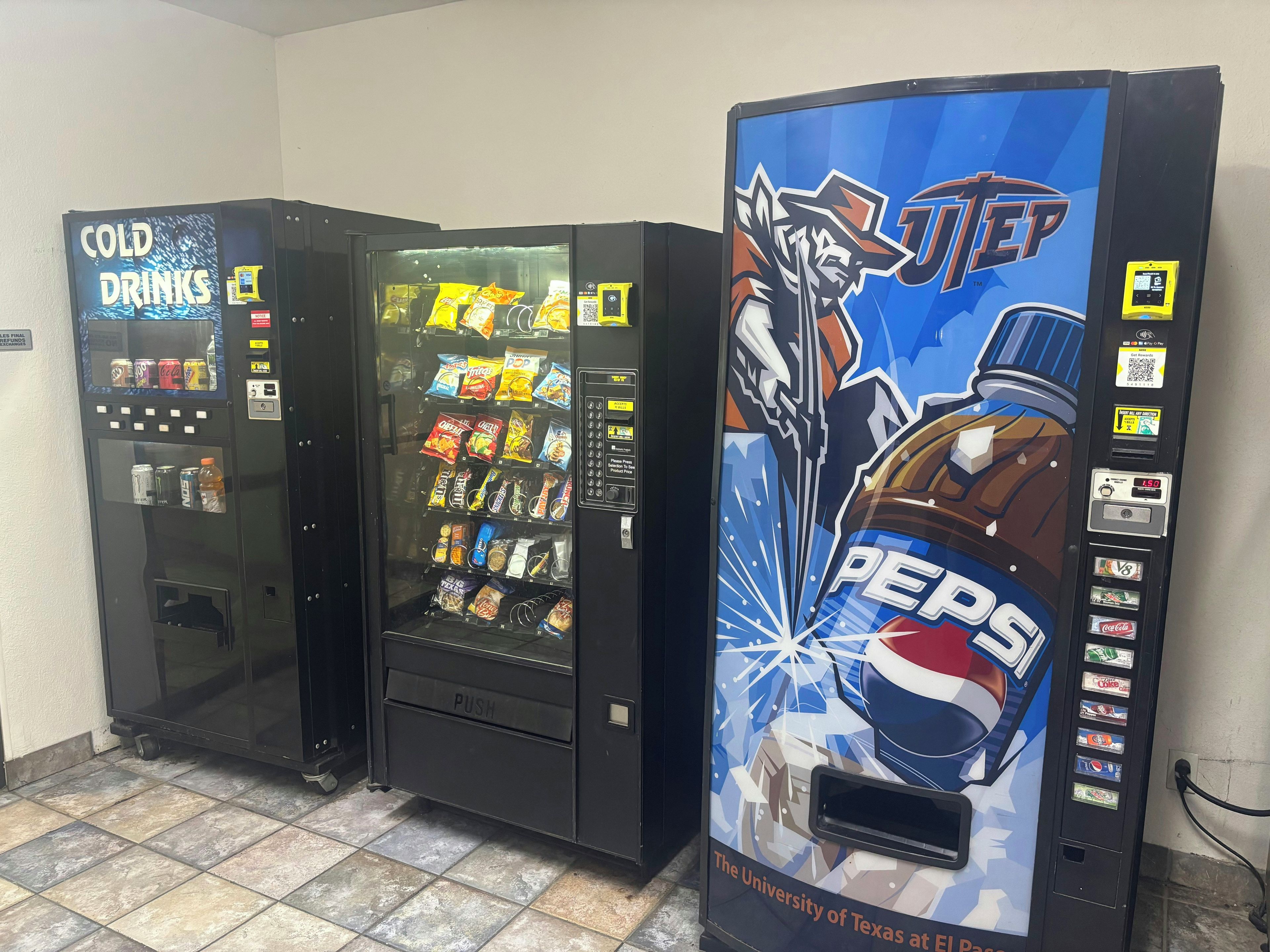 Three vending machines with various snacks and drinks, including a Pepsi machine.
