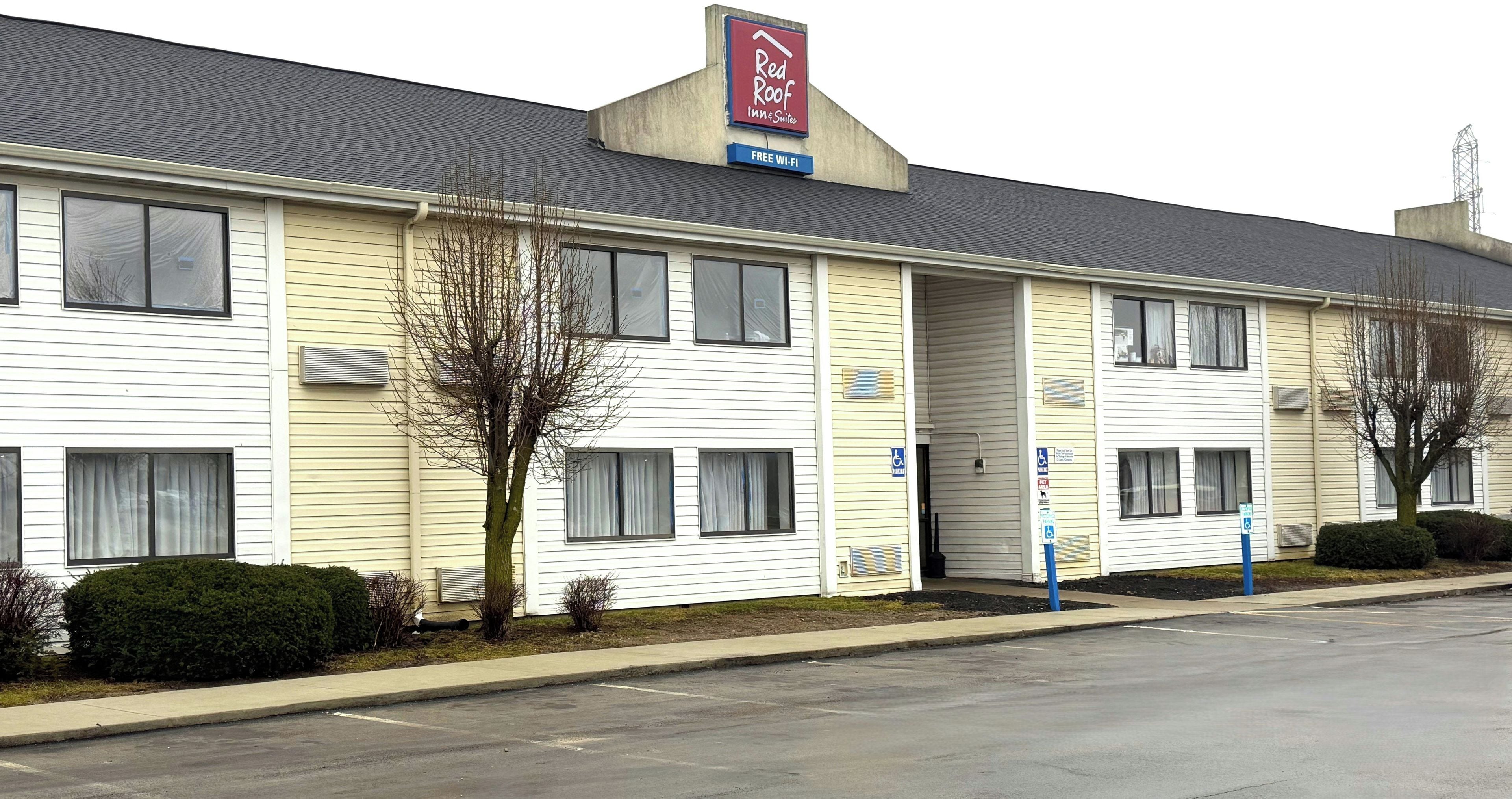 A Red Roof Inn & Suites with a single-story structure, a covered entrance, and a parking lot.