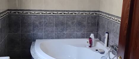 Un baño con una bañera independiente, un inodoro y un lavamanos.