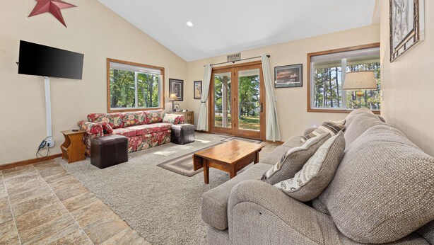 A living room with a sofa, a coffee table, a TV, and a star decoration on the wall.