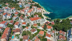 An aerial view of a coastal residential area with houses, a beach, and a pier. - Lovely apartment in Okrug Gornji (Okrug Gornji)