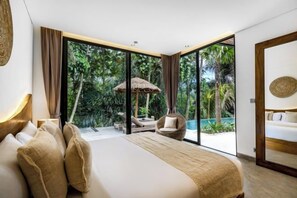 A bedroom with a large bed, a sitting area with a chair, and a view of a pool and greenery. - Villa Jungle Rendez Vous by BaliSuperHost (Bali)