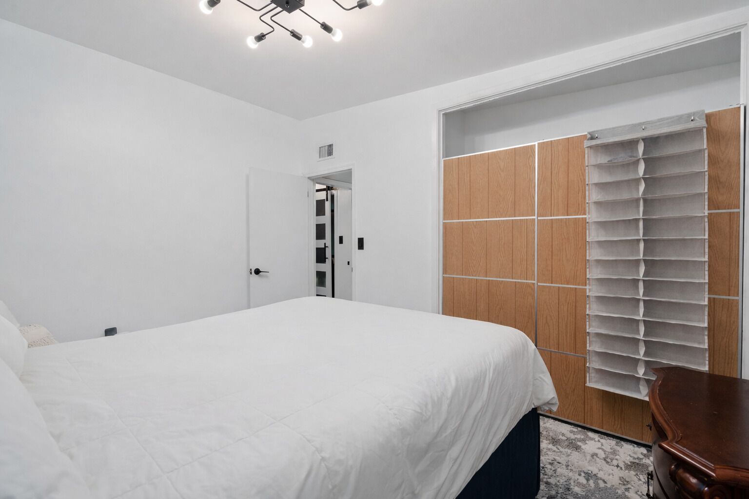 Ein Schlafzimmer mit Bett, Kleiderschrank und Schreibtisch.