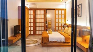 A bedroom with a bed, bedside tables, a TV, and a wardrobe with sliding doors. - Paz Tropical Villa Ubud by Omkara Experience (Bali)