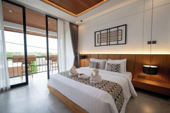 A modern hotel room with a large bed, a wooden ceiling, a view of the outdoors, and a framed artwork on the wall. - Omkara Dharman Ubud Villa (Bali)