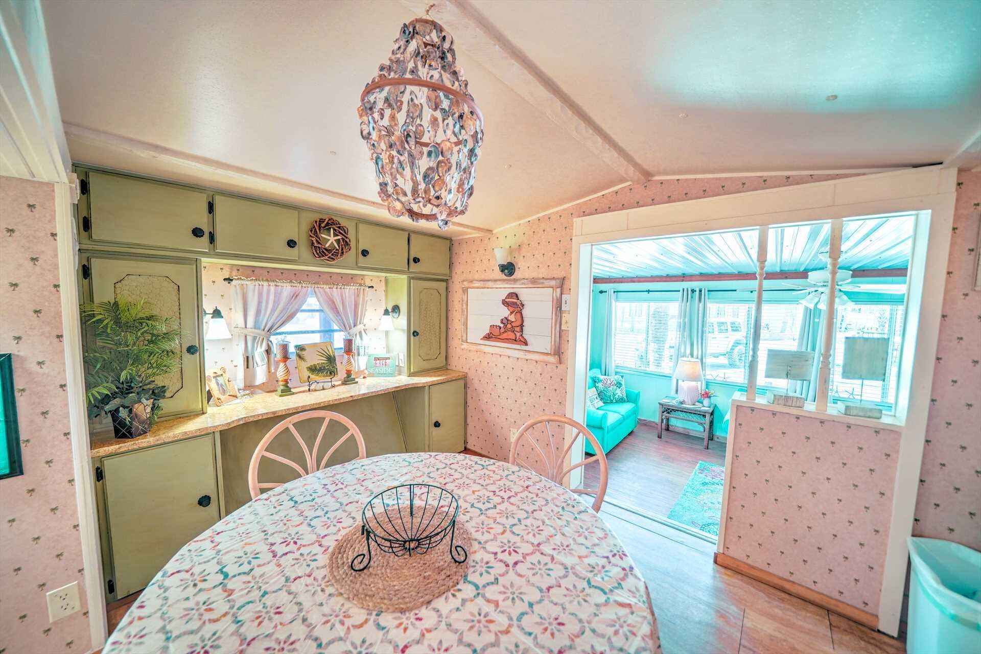 A cozy kitchen with a dining table, chairs, and a chandelier.