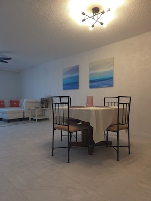 Ein Essbereich mit Tisch und Stühlen, einer Couch und zwei Bildern an der Wand.