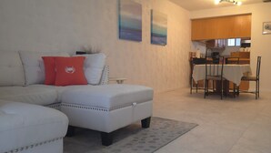 A living room with a sectional sofa, a dining area with a table and chairs, and a ceiling fan. - Perfect Punta Gorda Location Resort Pool & Harbor (Port Charlotte)