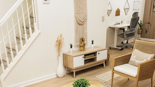 A modern living room with a round wooden coffee table, a white sofa, a wicker chair, a wooden cabinet, and a staircase. - Peaceful 2-bedroom townhome with AC in Lawrenceville (Lawrenceville)