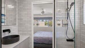 A modern bathroom with a large window, a built-in sink, and a shower. - Trade Winds Unit 5, 52 Edmund St, Kings Beach (Kings Beach)