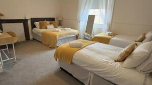 Ein Hotelzimmer mit zwei Betten, einem Schreibtisch und einem Stuhl.