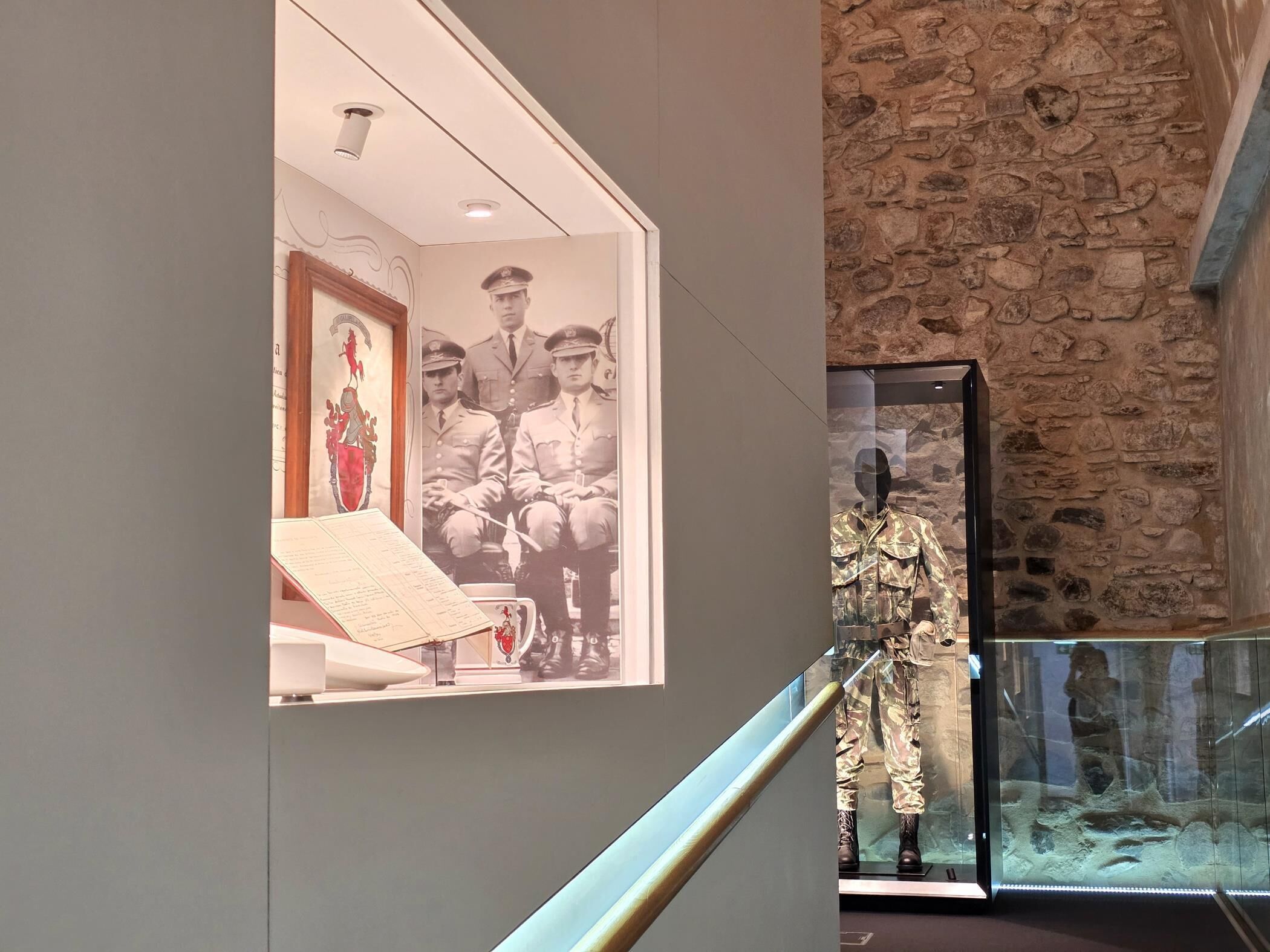 Una exhibición de museo con un uniforme militar y una fotografía enmarco de soldados.