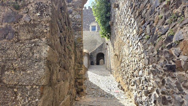 A narrow cobblestone alley flanked by stone walls, leading to an arched doorway. - Aconchego da Vila | Serra Flat | Castelo de Vide (Castelo de Vide)
