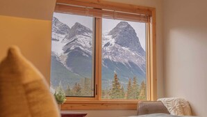 Un dormitorio con un amplio ventanal que ofrece vistas a la montaña.