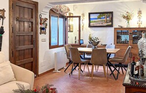 A dining area with a wooden table and chairs, a large window with a view, and a decorative mirror. - Luxurious home in Mijas (Mijas)
