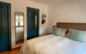 A bedroom with a bed, a nightstand, a lamp, and a mirror. - Luxurious home in Mijas (Mijas)