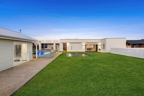 A modern house with a swimming pool, a covered patio, and a fenced backyard. - Luxury Bellbrae Retreat w  Pool, Spa & 12 Guests (Bellbrae)