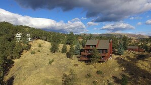 A large, two-story house with a balcony and a small cabin nearby, surrounded by a forested hillside. - Mountain View Retreat, Year Round Sunshine
1 bed, 1 renovated bath in Boulder (Boulder)