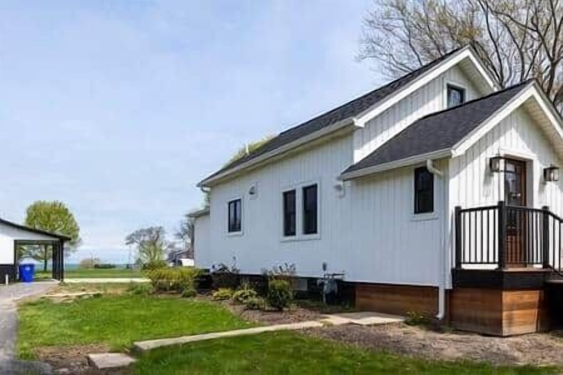 A single-story house with a front porch, a small attached garage, and a clear sky.