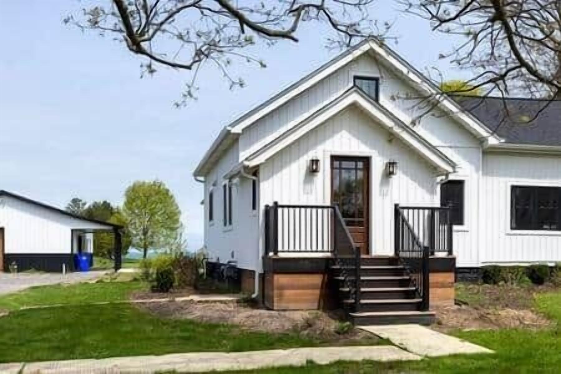A single-story house with a front porch, a visible staircase, and a small front yard.