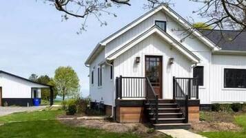A single-story house with a front porch, a visible staircase, and a small front yard.