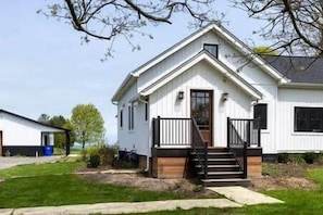 A single-story house with a front porch, a visible staircase, and a small front yard.