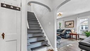 A staircase leading to a living area with a couch and a lamp. - LVR - The Yellow House on 3rd (Lewiston)