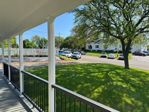Ein überdachter Balkon mit Blick auf einen Parkplatz und Häuser im Hintergrund.
