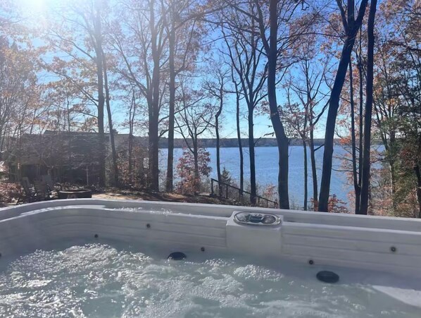 A hot tub with a view of a lake and trees. - Hot Tub, Fire Pit, Kayak,Water Slide, Pet Friendly (Bracey)