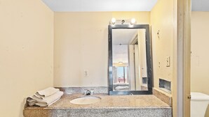 A bathroom with a granite countertop, a sink, and a mirror with lights. - Luxury Inn By Hotel O Hattiesburg, MS (Hattiesburg)
