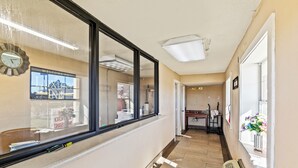 A hotel corridor with a clock, a welcome sign, and a window with a view of the outside. - Luxury Inn By Hotel O Hattiesburg, MS (Hattiesburg)