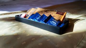 Een schaal met chocolade op een bed met een decoratieve sprei.