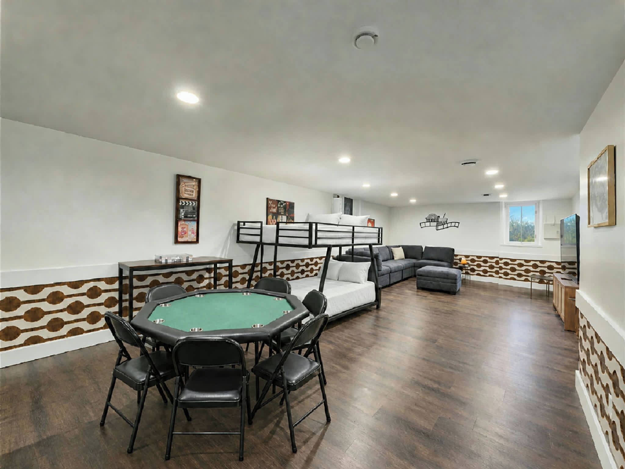 A room with a pool table, a sofa, and a bunk bed.