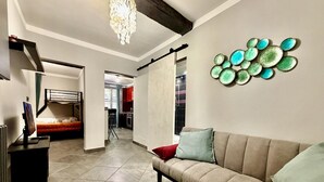 A modern living room with a sofa, a chandelier, and a wall art piece. - DIMORA DI PRE   ACQUARIO   GENOVABB.IT (GENOVA)