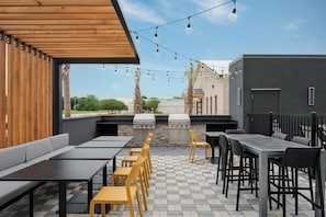 An outdoor patio with seating, a grill, and string lights. - Home2 Suites By Hilton Lafayette I-10 (Lafayette)