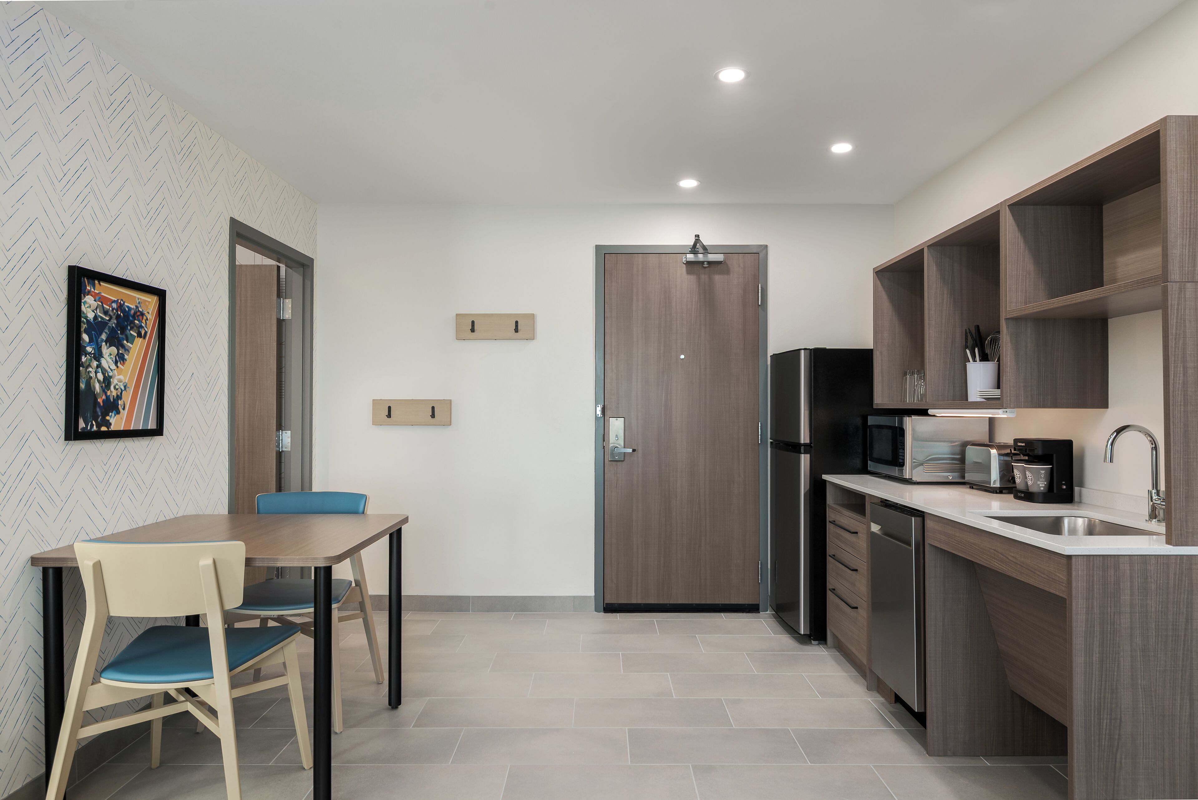 Una cocina moderna con comedor, armarios de madera y un microondas.