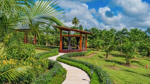 A garden with a gazebo, a pathway, and various plants. - Hotel Sanctuarium Adults Only (La Fortuna)