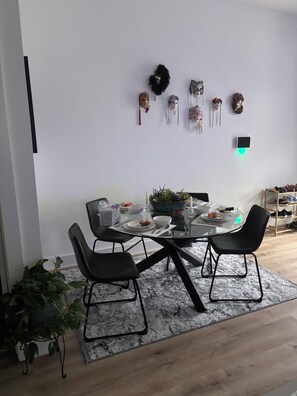 A dining area with a round table, black chairs, a potted plant, and wall-mounted decorations. - Fabulous 3-bedroom/3 bath apartment with Central Heating &AC in Houston (Houston)