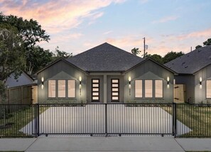 A two-story house with a dark roof, a front porch, and a gated driveway. - Fabulous 3-bedroom/3 bath apartment with Central Heating &AC in Houston (Houston)