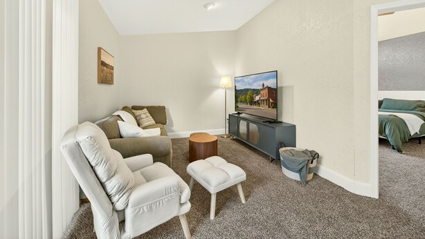 A modern hotel room with a sofa, a small table, a television, and a bed. - Jville Gem- Walk downtown (Jacksonville)
